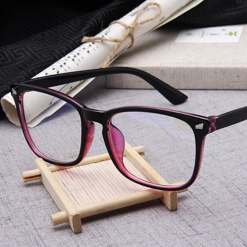 Premium Optics blue light glasses in color purple on a small wooden stand with a textured surface